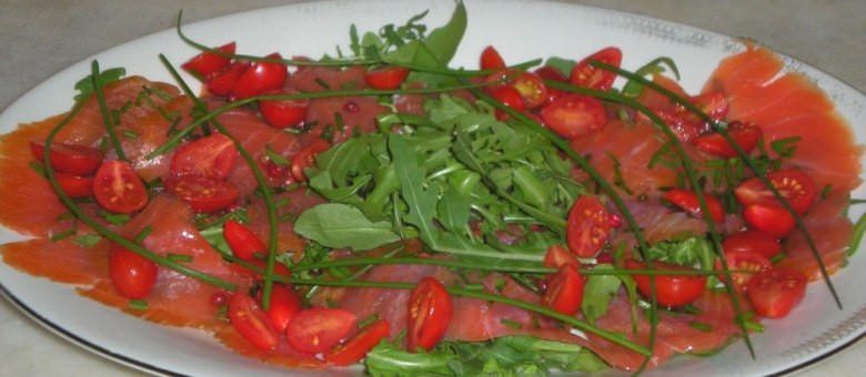 Filetti di trota salmonata affumicata in carpaccio con rucola ed erba cipollina