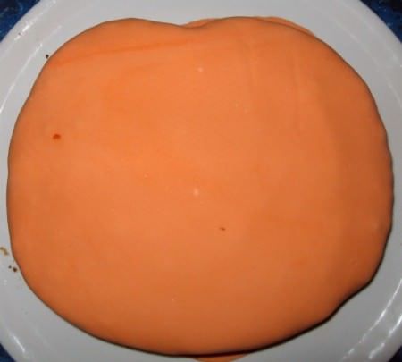 La torta ricoperta con la pasta di zucchero arancione