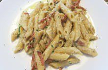 Penne con crema di noci, carciofini e speck