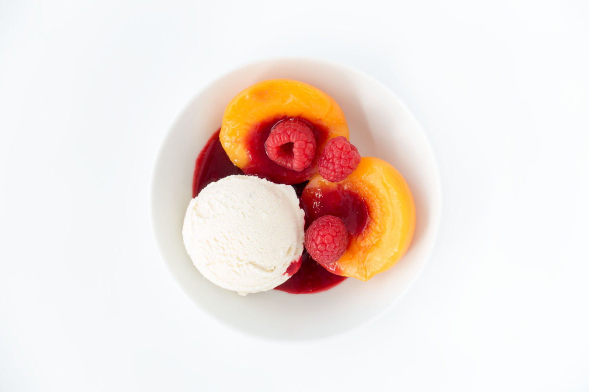 È un dolce al cucchiaio a base di frutta e gelato pronto in pochi minuti, ma è anche un dessert dalla storia curiosa: conosci la pesca melba?