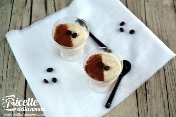 Semifreddo al caffè e latte condensato servito in bicchieri trasparenti, guarnito con cacao in polvere e chicchi di caffè.