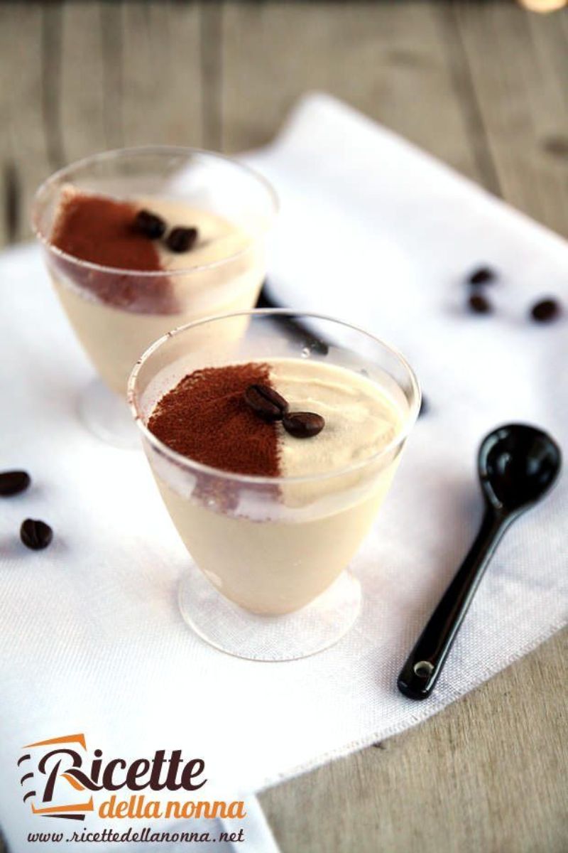 Semifreddo al caffè e latte condensato servito in bicchieri trasparenti, guarnito con cacao in polvere e chicchi di caffè. Primo piano.