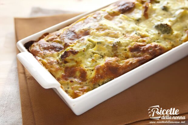Sformato di broccoli appena sfornato in una pirofila bianca rettangolare, con superficie dorata e leggermente gratinata.