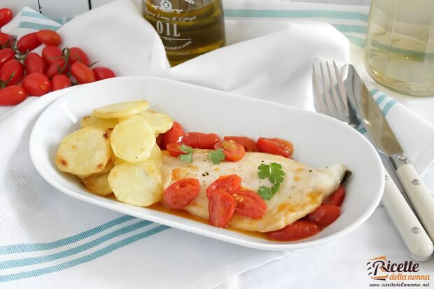 Spigola all'acqua pazza in un piatto bianco, con sopra prezzemolo, pomodori e capperi