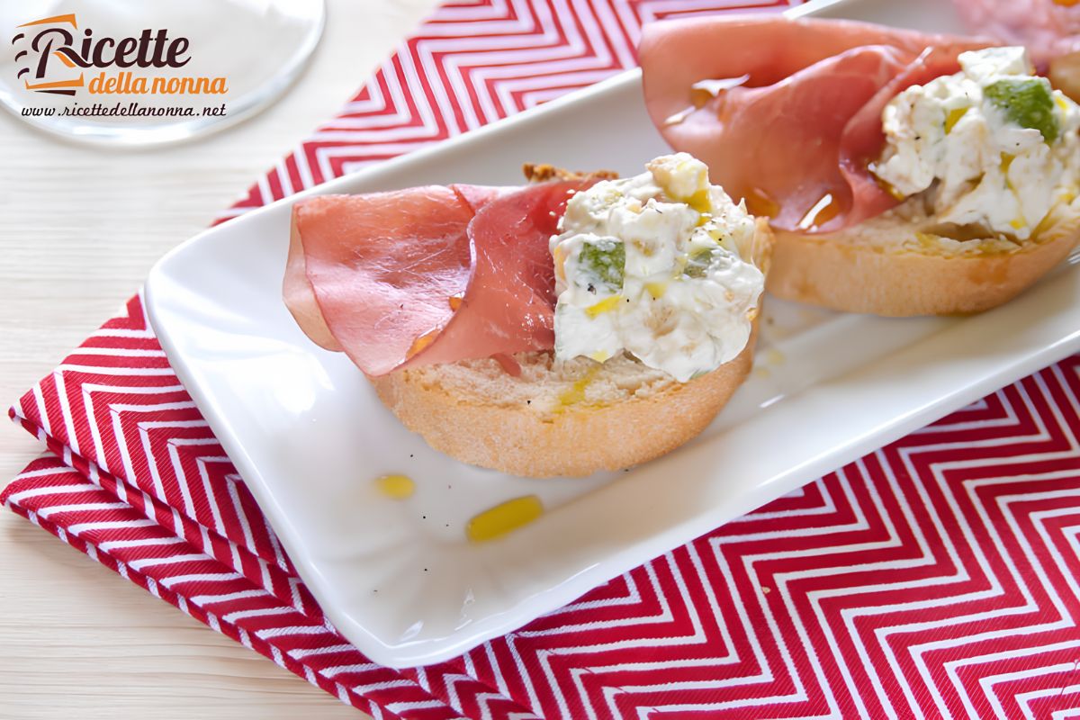Due bruschette zucchine e bresaola su un piatto bianco sopra una tovaglia rossa. Primo piano