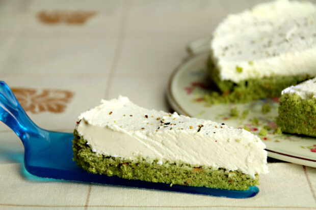 Fetta di cheesecake salata ricotta e pesto, con il resto sullo sfondo