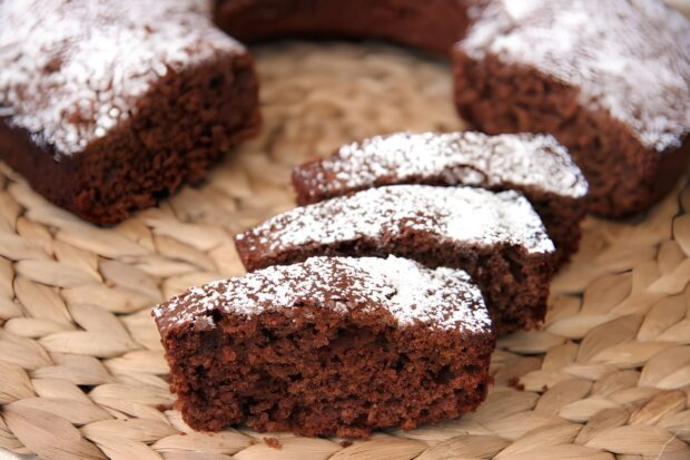 Ciambella integrale allo yogurt al cocco e cioccolata, con 3 fette tagliate, su piatto di vimini