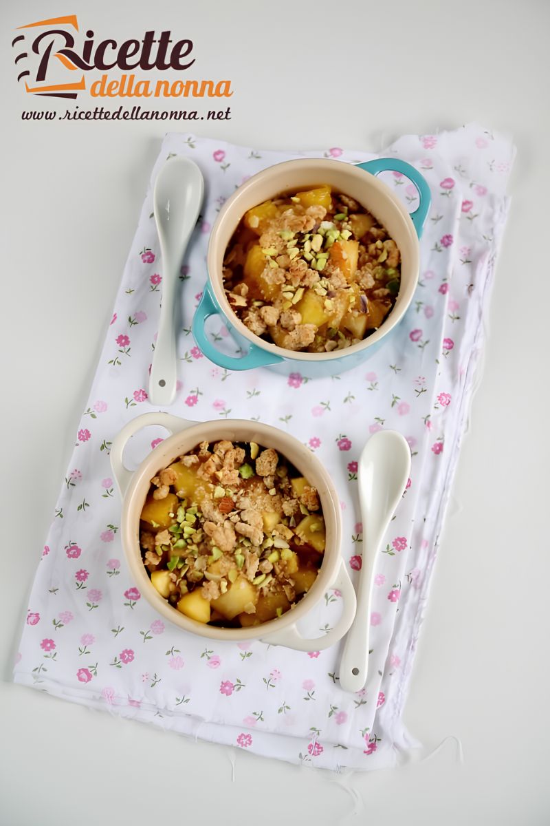 Crumble avena e mele con ananas in due terrine, una bianca ed una azzurra, su una tovaglia bianca a fiori