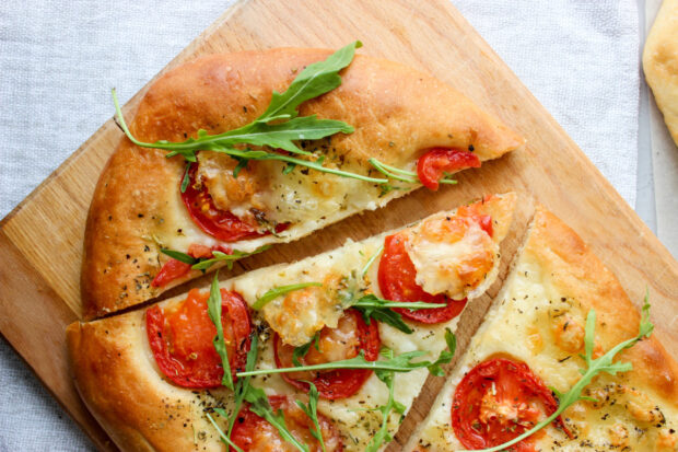 Tre spicchi di focaccia con pomodorini su tagliere di legno