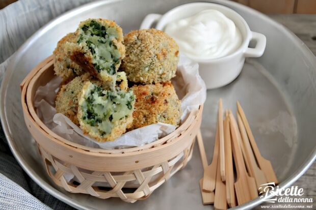 Polpette di patate e spinaci, con provola, servite in un cestino di vimini con vicino della panna acida e degli stecchini