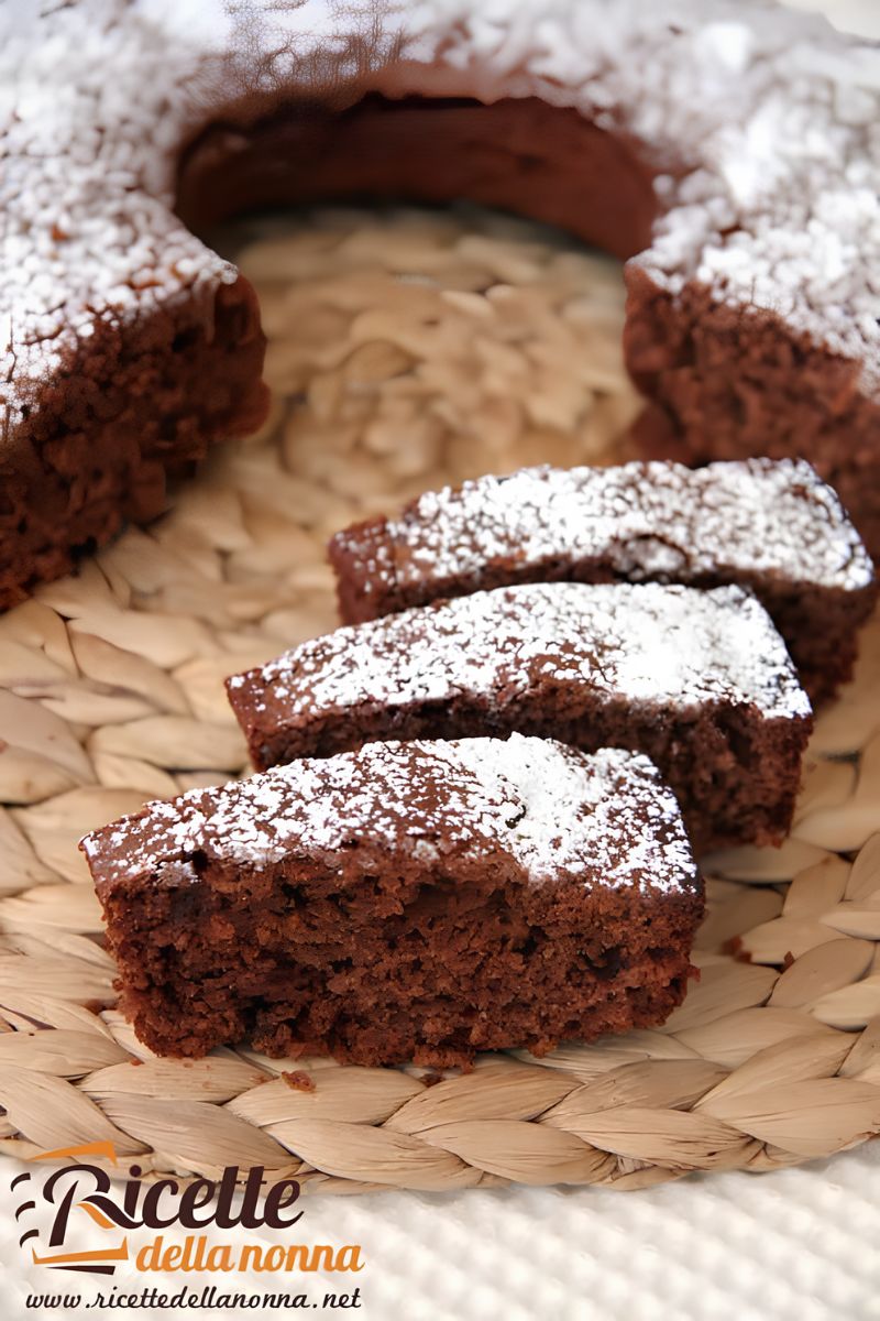 Ciambella integrale allo yogurt al cocco e cioccolata, con 3 fette tagliate, su piatto di vimini. Primo piano