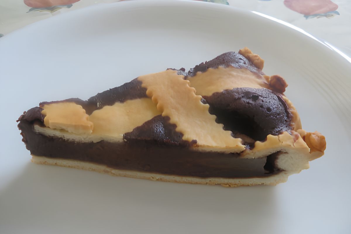 Fetta di crostata pere e cioccolato con la crema visibilmente morbida, adagiata su un piatto