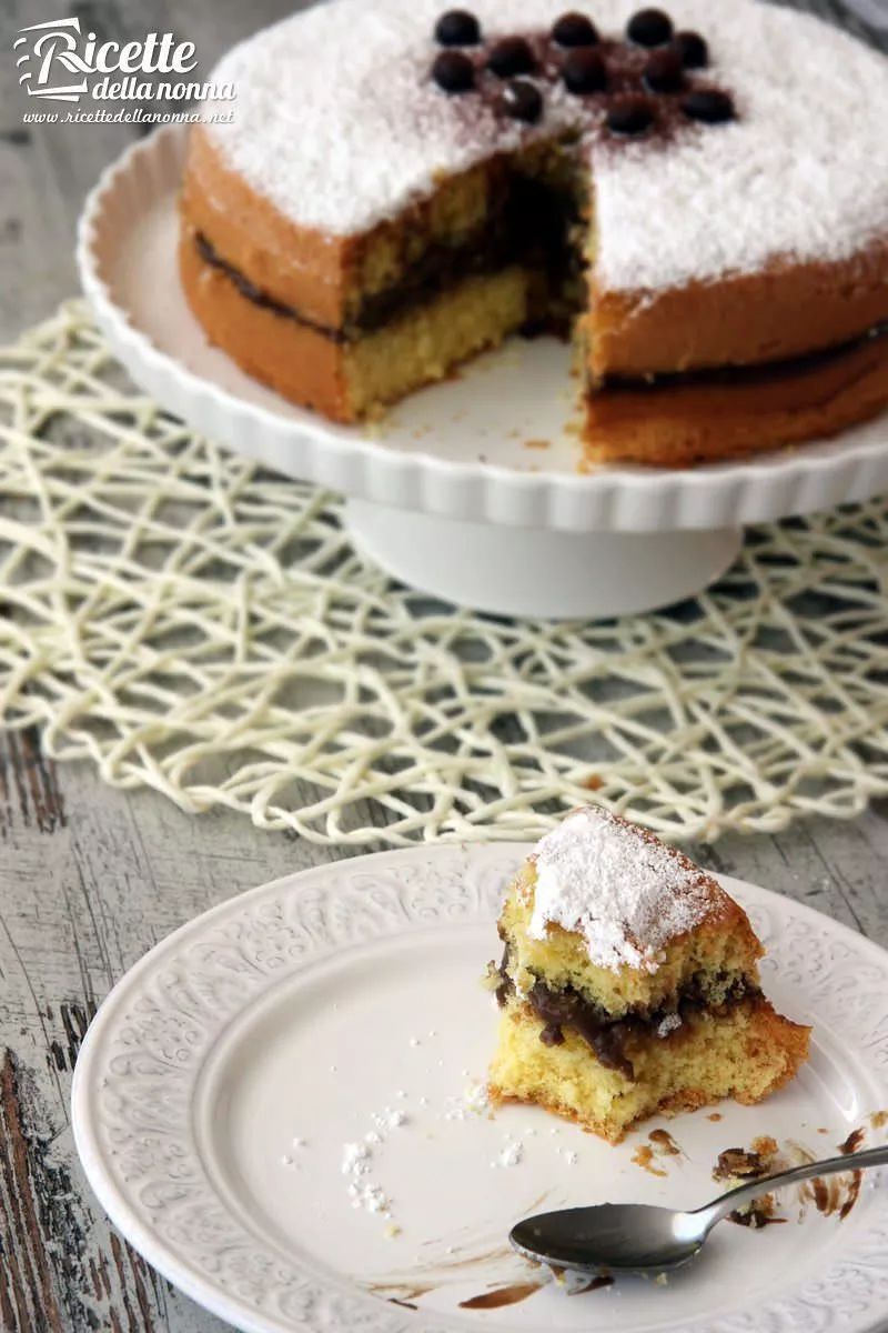 Torta al caffè con base genoise, farcita a strato, coperta di zucchero a velo e decorata con chicchi di caffè al cioccolato
