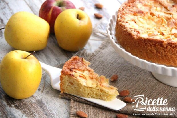 Fetta di torta plumcake alle mele. 4 mele alla sinistra e il resto della torta sullo sfondo