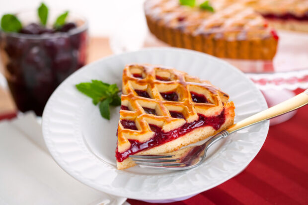 Fetta di crostata light su un piatto bianco, con dietro il resto della crostata sullo sfondo