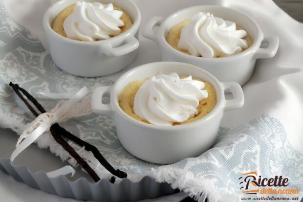 Tre dessert light alla vaniglia e latte in piccole coppette bianche, con sopra della panna