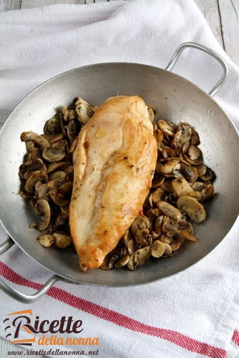 Padella con delle fettine di petto di pollo al Marsala, con un letto di funghi